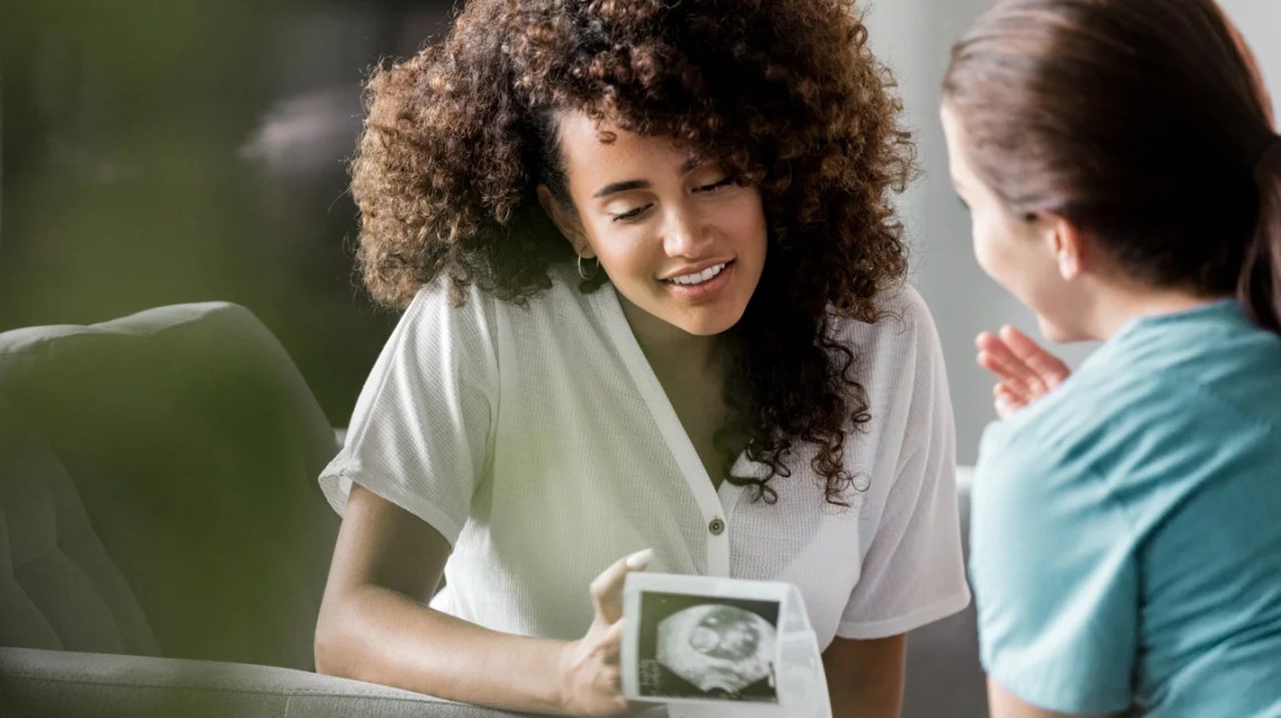 Two women sitting looking at a sonogram