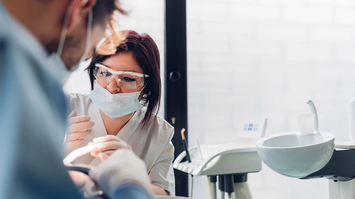 A dentist preparing to work on a patient who has signs of a tooth cavity. 