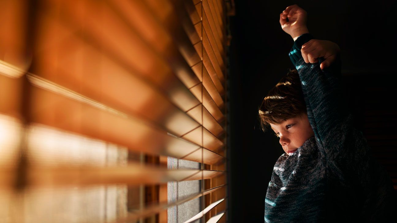 child with ADHD waking early and looking out the blinds-1